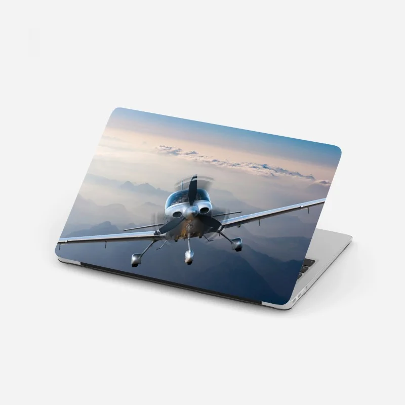 Pegatina para portátil avión monomotor sobre paisaje montañoso al amanecer