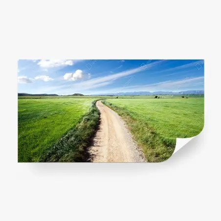 Fotomural camino campestre hacia montañas bajo cielo azul – Pixers®