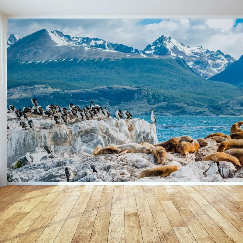 Fotomural colonia de lobos marinos y aves marinas frente a montañas nevadas