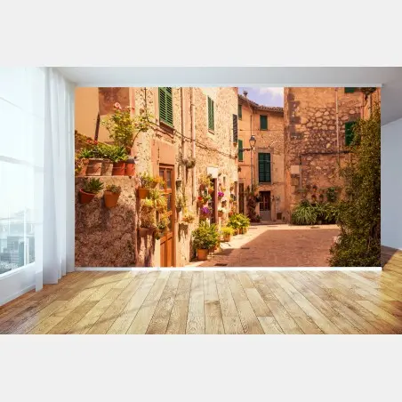 Fotomural calle mediterránea con macetas y luz dorada – Pixers®