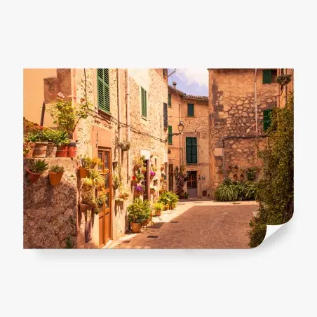 Fotomural calle mediterránea con macetas y luz dorada – Pixers®