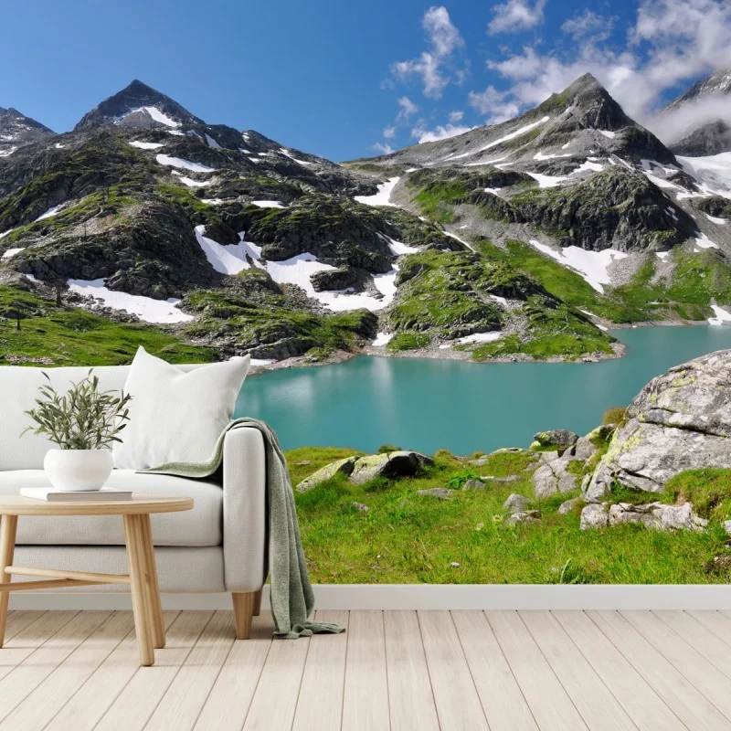 Fotomural lago alpino turquesa entre montañas y praderas
