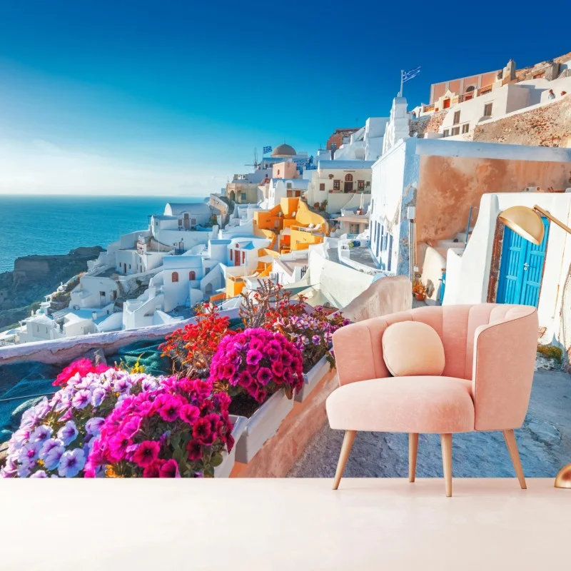 Fotomural paisaje costero de Santorini con casas blancas y flores