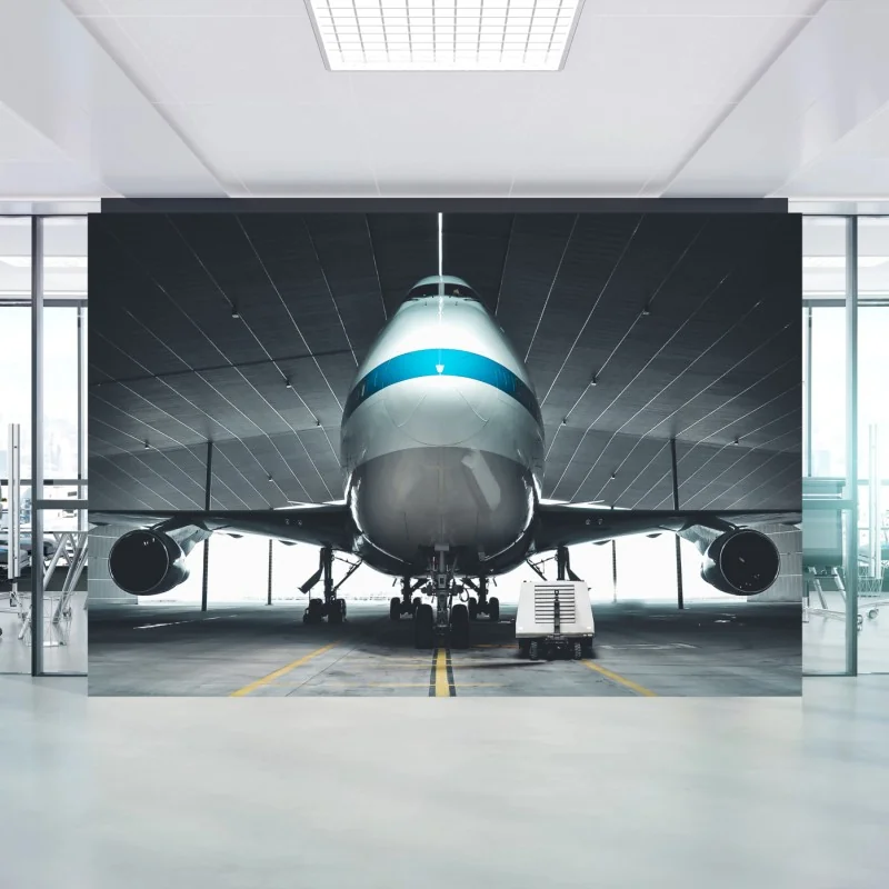 Fotomural frontal de avión en hangar industrial